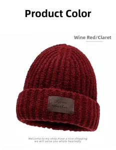Detail of claret knitted beanie with brown leather logo patch and textured wool finish
