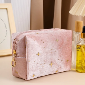 Detail of pink velvet makeup bag with gold stars and premium metal zipper closure