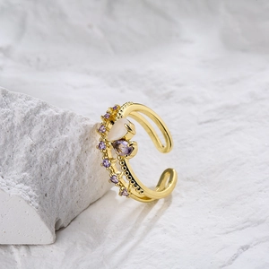 18K gold-plated heart ring with purple and white zircon drops on a white rock surface