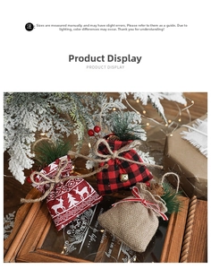 Detailed view of burlap Christmas gift bags with pine needles, red berries and gold bells