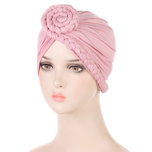 Dettaglio di turbante rosa boho con nodo floreale 3D e trama intrecciata laterale
