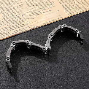 Detail of black and silver biker chain bracelet on dark matte surface with vintage newspaper