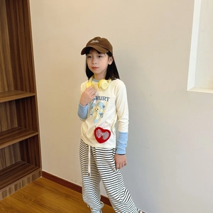 Kids cream long sleeve T-shirt with striped pants and a red heart shaped crossbody bag
