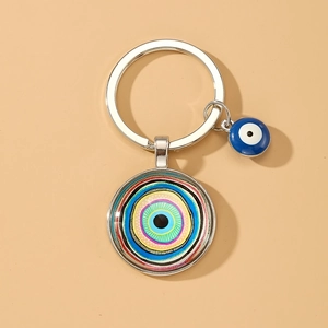 Detailed view of silver evil eye keychain with blue bead and circular glass pendant