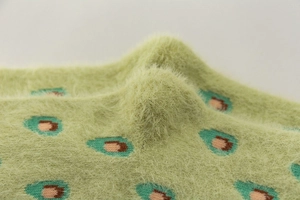 Macro view of green mink velvet fabric featuring soft knit texture and avocado pattern