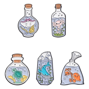 Set of 5 cute ocean creature enamel pins featuring clownfish and blue whale in glass bottles