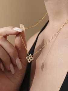Nahaufnahme der goldenen Kette mit Sternenanhänger und fein gefassten weißen Zirkonias