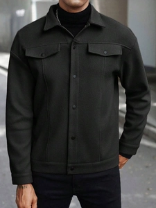 Close-up detail of black wool blend jacket with lapel collar and metal button pockets