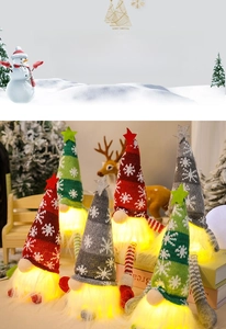 Close-up of glowing Christmas gnomes with knitted star hats and white snowflake patterns