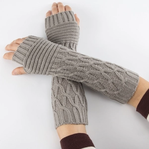 Detailed close-up of grey cable-knit long fingerless gloves showing texture and patterns