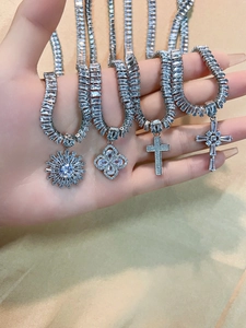 Macro view of luxurious silver cross and sunburst pendants with sparkling cubic zirconia