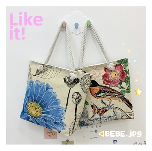 Detail of floral canvas tote bags with daisy and bird patterns on hanging cloud hooks
