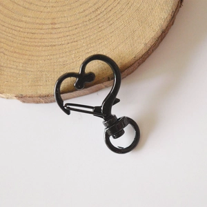 Black heart-shaped alloy lobster clasp for keychains and DIY crafts on wood base