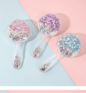 Close-up of three glitter hairbrushes with pink, purple and blue sequins in liquid filling