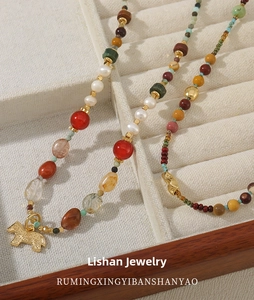 Close-up of beaded necklace with African turquoise, freshwater pearls and golden pony pendant