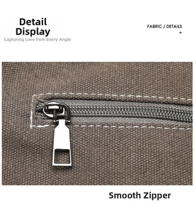 Detail shot of smooth metal zipper and white contrast stitching on a brown canvas tote bag