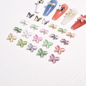 Makro-Detail von 3D-Schmetterling-Nagelcharms mit Katzenaugen-Opal und Legierung
