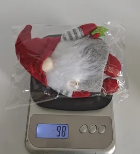 Detail showing a Christmas gnome plush weighing approximately 98g on a digital scale
