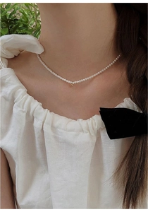 Close-up of fresh water pearl choker necklace with gold bead accent on model neck