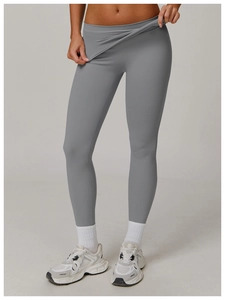 Detail of high-waisted grey yoga pants showing cross-waist design and elastic fabric