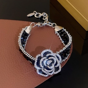 Macro detail of French style camellia bracelet with black faceted beads and crystals