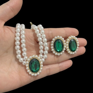 Detail of double-layer pearl necklace and earrings with green opal in gold setting