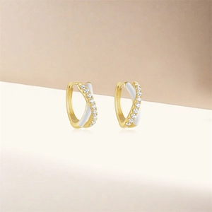 Detailed macro view of S925 silver hoop earrings with white enamel and sparkling crystals