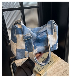 Détail du sac polochon en patchwork de denim bleu avec boucle en métal argenté réglable