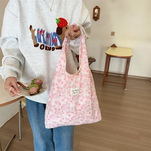 Floral print pink handbag with quilted fabric texture and small branding tag detail
