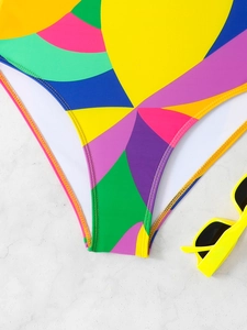 Detail view of multi-color patchwork swimwear fabric and precision stitching on white marble