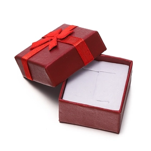 Close-up of red square jewelry box with ribbon bow and soft white foam insert