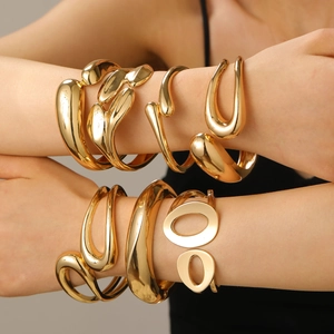 Exaggerated golden irregular cuff bracelets in organic shapes on a model's arm