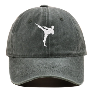 Vista detallada del bordado blanco de artes marciales en una gorra de béisbol gris desgastada