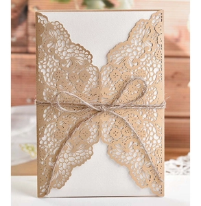 Detail of laser-cut lace invitation with kraft paper and rustic hemp rope bow