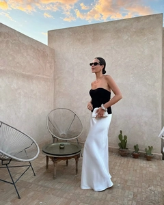 Ensemble élégant jupe longue en soie blanche et bustier noir dans un décor de luxe