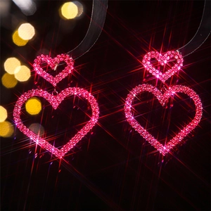 Sparkling double heart dangle earrings with crystals and pink rhinestones on black background