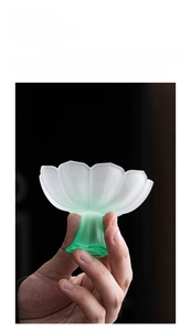 Close-up of frosted petal glass high-foot cup with white to emerald green gradient finish
