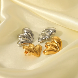 Boucles d'oreilles polies en acier inoxydable doré et argenté sur tissu de soie jaune