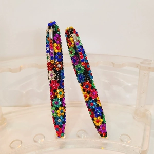 Detailed macro view of colorful crystal rhinestones on the rotating metal ballpoint pen