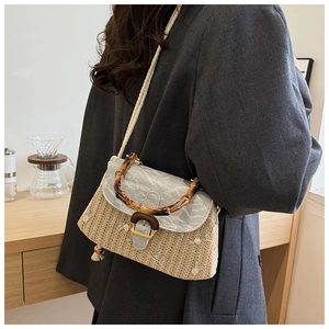 Detail of straw woven crossbody bag with bamboo handle and premium grey PU leather lid