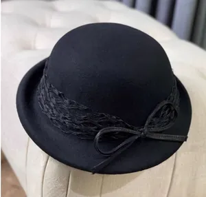 Close-up of black wool felt bowler hat with mesh lace veil and bow detail