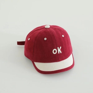 Detailansicht einer weichen Baby-Baseballkappe in Rot und Weiß mit 'ok'-Stickerei