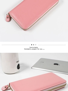 Detalle de la cartera rosa de cuero granulado con cremallera de metal dorado y correa larga