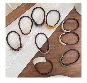 Flat lay of acetate hair ties in various Morandi colors with resin rectangle accents