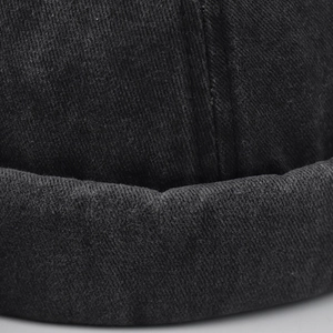 Macro shot of washed cotton twill fabric and thick rolled edge of a black docker hat
