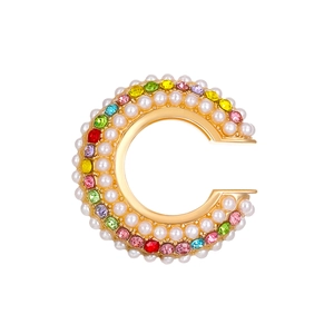 Detailed view of a gold C-shaped ear cuff featuring colorful crystals and white pearls