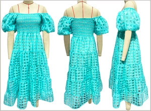 Detail of off-the-shoulder puff sleeves and tiered plaid texture on a turquoise maxi dress