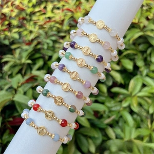 Close-up of handmade 18k gold plated beaded bracelets with colorful stones and medallions