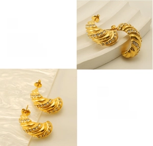 Détail de créoles dorées 18 carats avec texture en spirale et incrustations de zircons