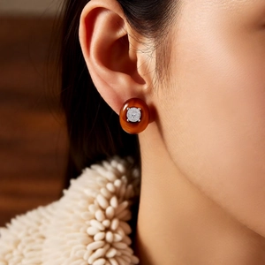 Detailed close-up of a vintage oval tiger eye stud earring with zircon on an ear